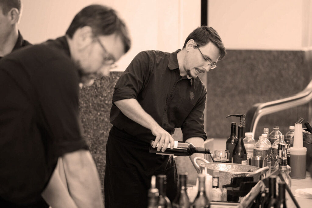 catering staff pouring wine