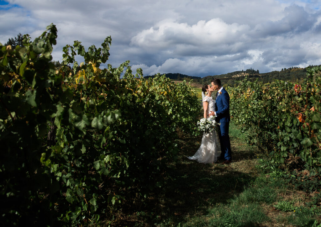 bride and groom kissing in a vineyard