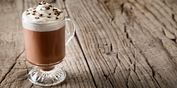 hot cocoa in a glass mug with whipped cream