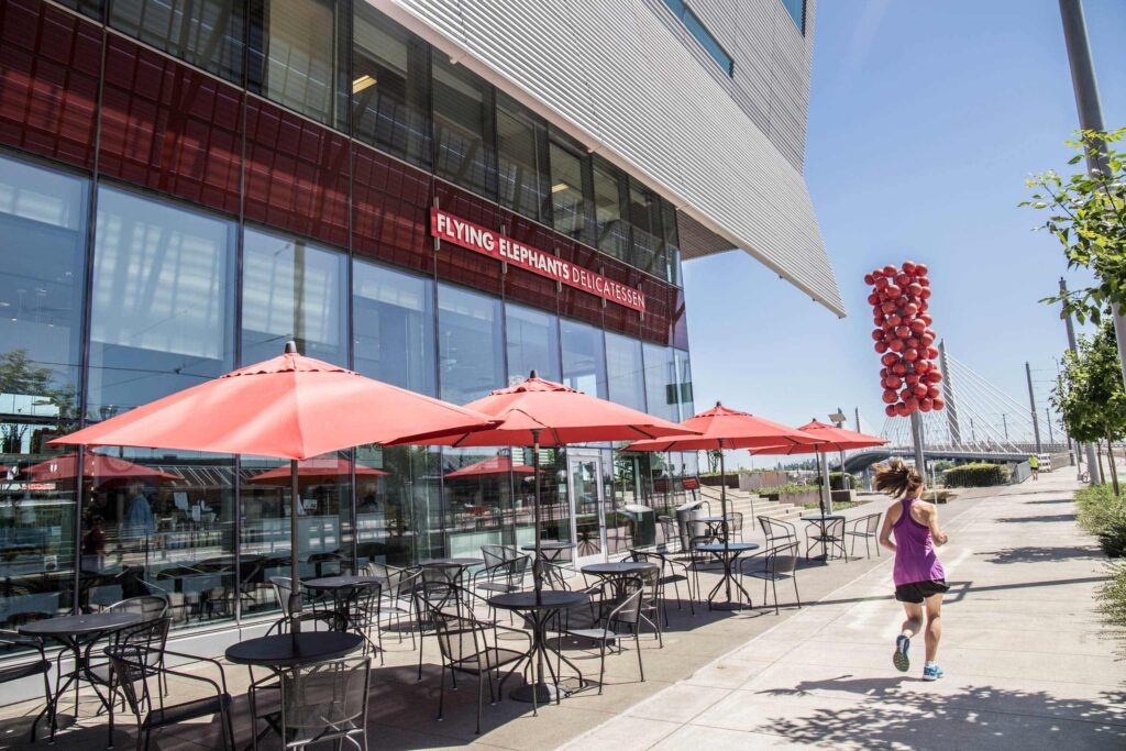 Elephants Delicatessen Flying Elephants at South Waterfront storefront with jogger running by