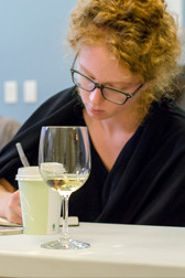 woman taking notes with a glass of wine and a cup of coffee