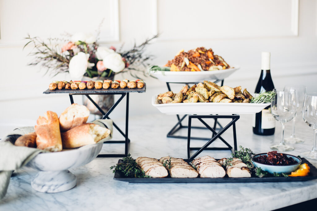 Catering spread featuring chicken, bread, potatoes, and wine