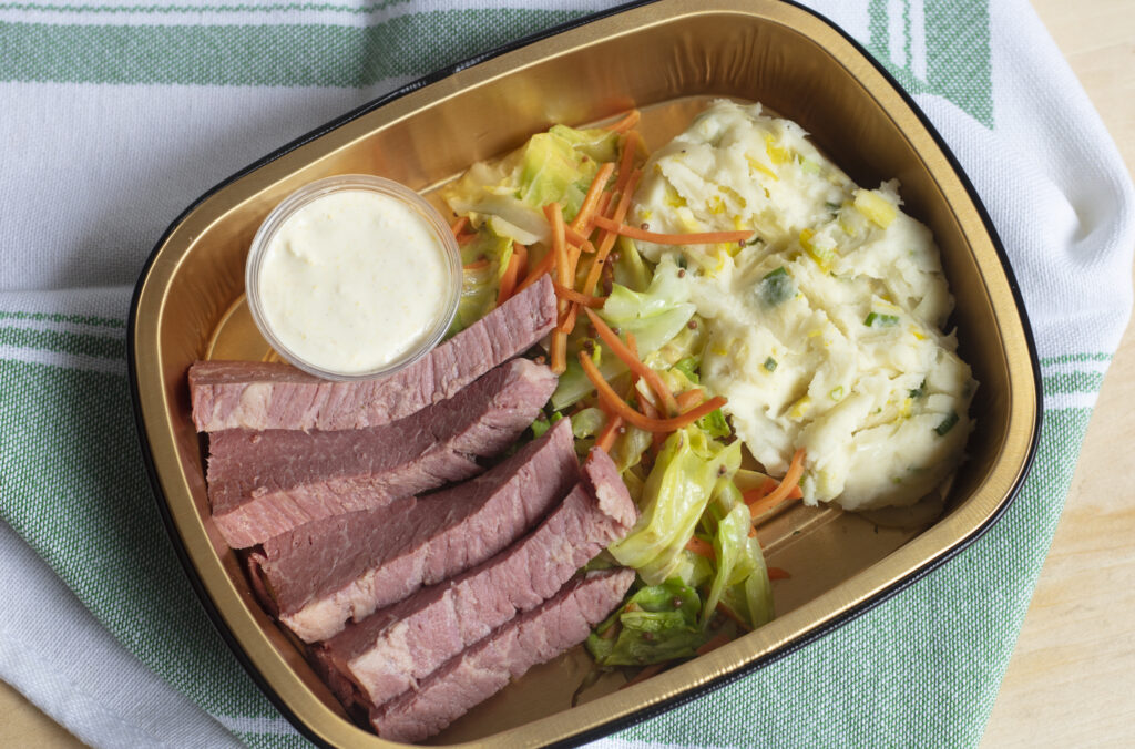 Corned beef with cabbage and mustard seed sauce in a gold container