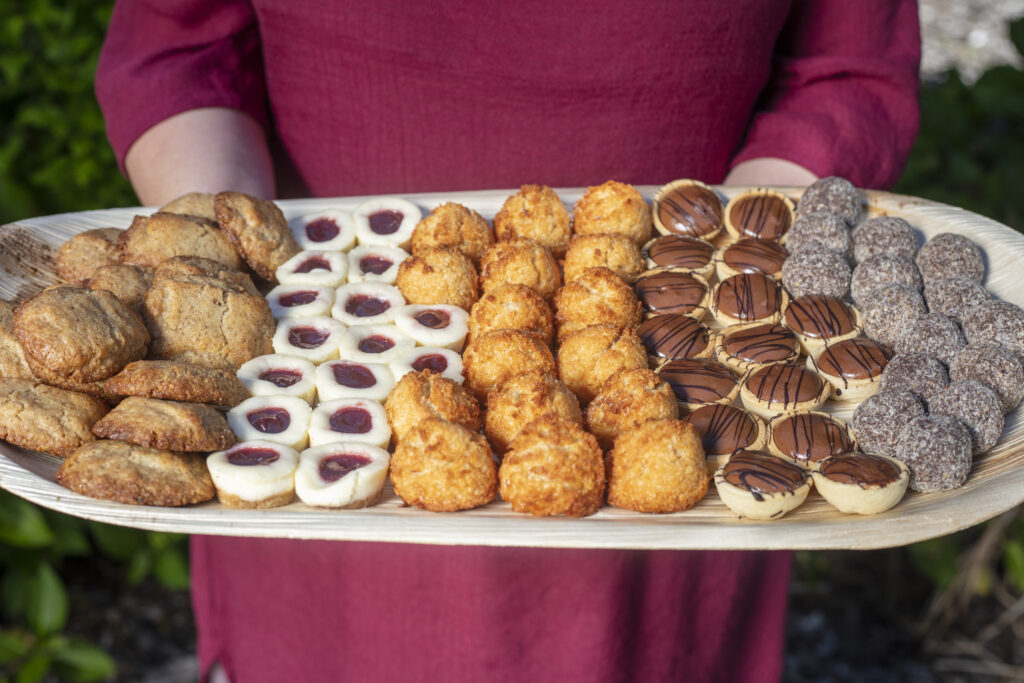 Person holding a dessert platter in a park wearing a red dress