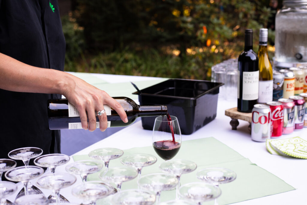 server pouring a glass of red wine